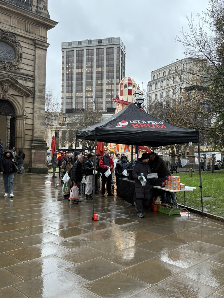Volunteers serving under the Let's Feed Brum gazebo at Birmingham Cathedral